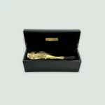 Armand De Brignac Brut Gold Champagne bottle alongside its elegant black and gold gift box.