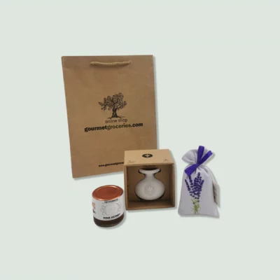 A set of gourmet items including a brown paper gift bag, a jar of marjoram seasoning, a bottle of olive oil in a box, and a fabric bag of lavender. The gift bag has a rope handle and the logo "gourmetgroceries.com" printed on it.