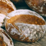 Sliced rustic bread loaf on a wooden board, ideal for demonstrating the performance of a serrated bread knife