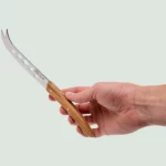 Close-up of polished blade and perforated edge on soft cheese knife