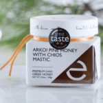 A jar of Arkoi Pine Greek Honey with Chios Mastic displayed in a gourmet kitchen setting