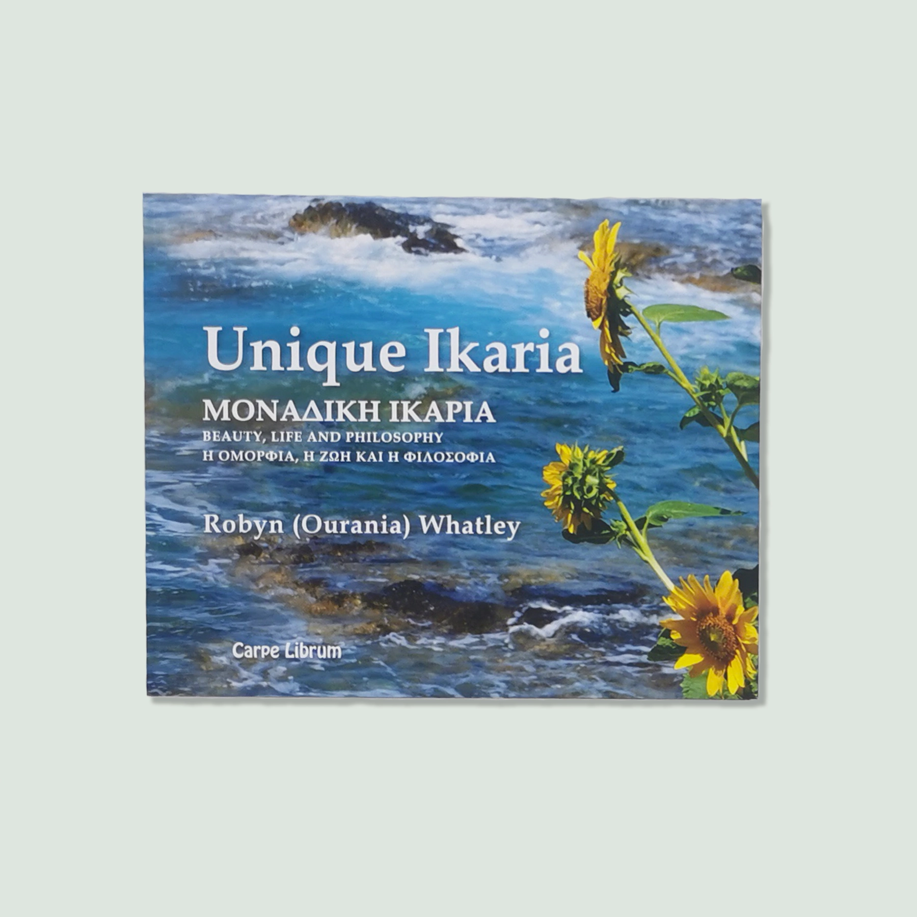 Ikaria Greece Book The book "Unique Ikaria Greece: Beauty, Life, and Philosophy" by Robyn (Ourania) Whatley. The cover features a scenic view of Ikaria with sunflowers and a coastal background.