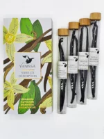 A box containing four vanilla pods in glass tubes by Vanissa. The box has a botanical design with vanilla flowers and pods. The vanilla pods are of two varieties: Bourbon Madagascar and D'Ouganda Planifolia, labeled.